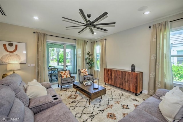 living room featuring ceiling fan and a healthy amount of sunlight