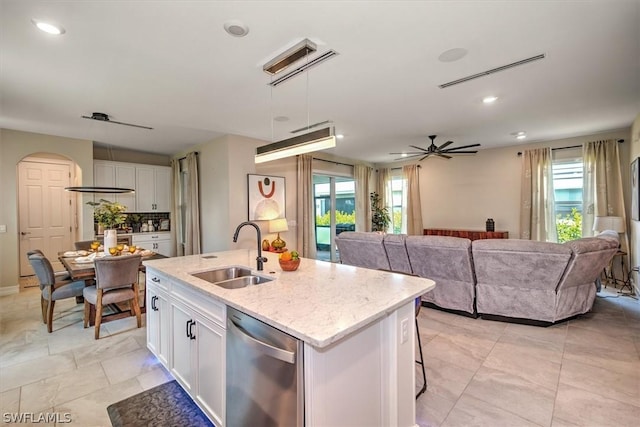 kitchen featuring ceiling fan, dishwasher, sink, an island with sink, and white cabinets