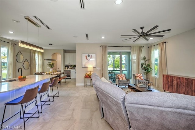 living room with ceiling fan, a healthy amount of sunlight, and sink