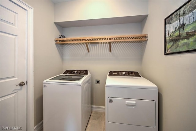 laundry area with washing machine and dryer and light tile patterned floors