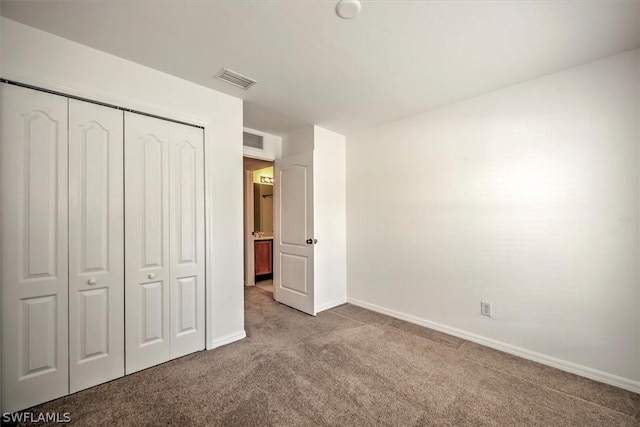 unfurnished bedroom featuring a closet and light colored carpet