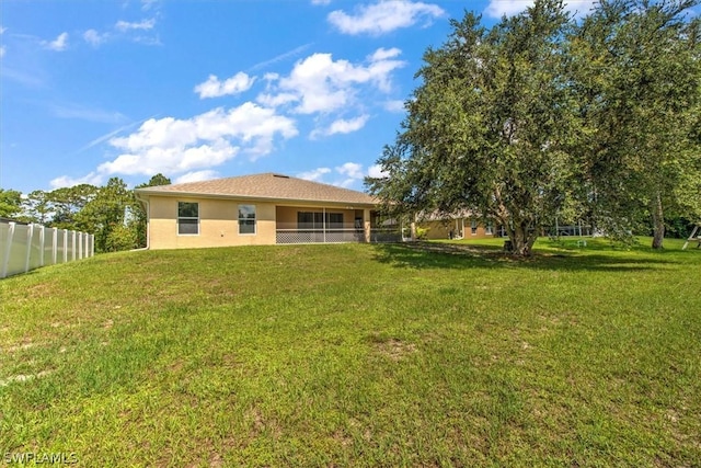 rear view of house featuring a lawn