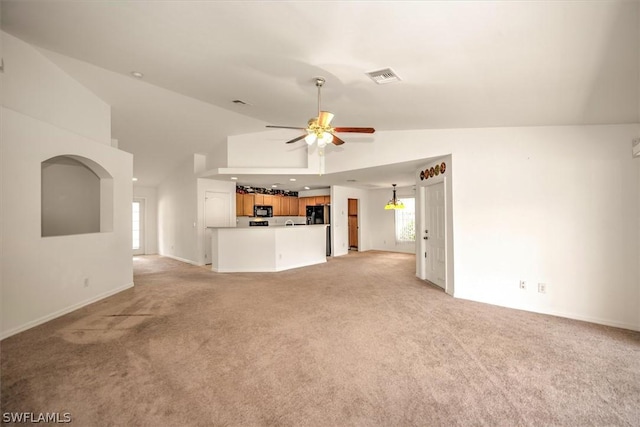 unfurnished living room with light carpet, high vaulted ceiling, and ceiling fan