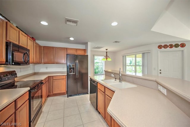 kitchen with pendant lighting, sink, light tile patterned floors, and black appliances