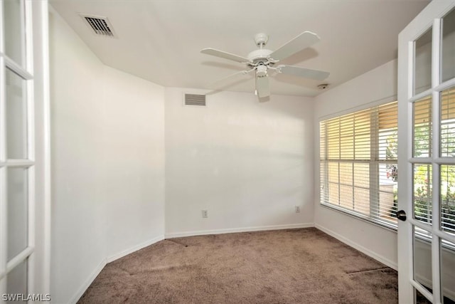 carpeted spare room with ceiling fan