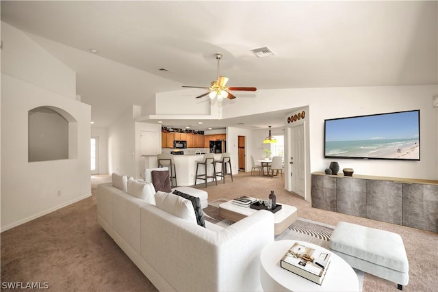 living room featuring ceiling fan, light colored carpet, and lofted ceiling