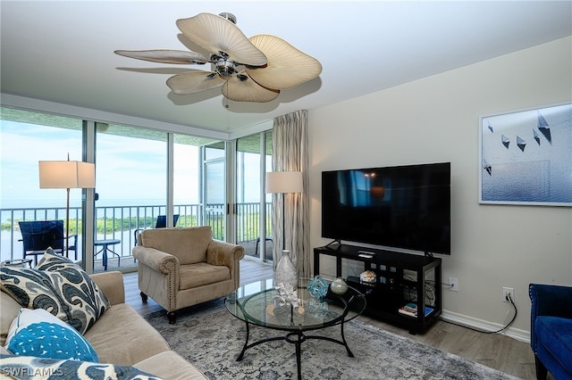 living room with a water view, a healthy amount of sunlight, hardwood / wood-style flooring, and ceiling fan