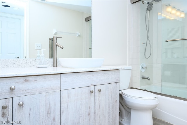 full bathroom with vanity, bath / shower combo with glass door, and toilet