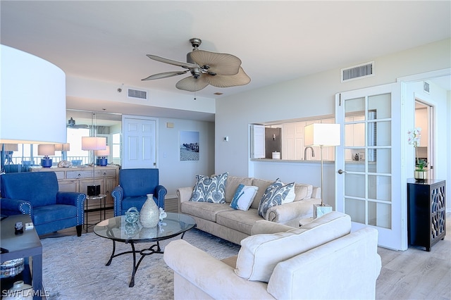 living room featuring light hardwood / wood-style flooring and ceiling fan