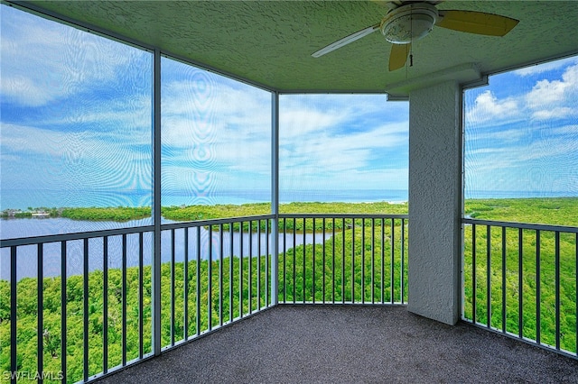 unfurnished sunroom with a water view and ceiling fan