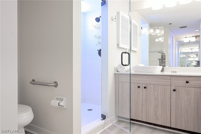 bathroom with tiled shower, toilet, and vanity