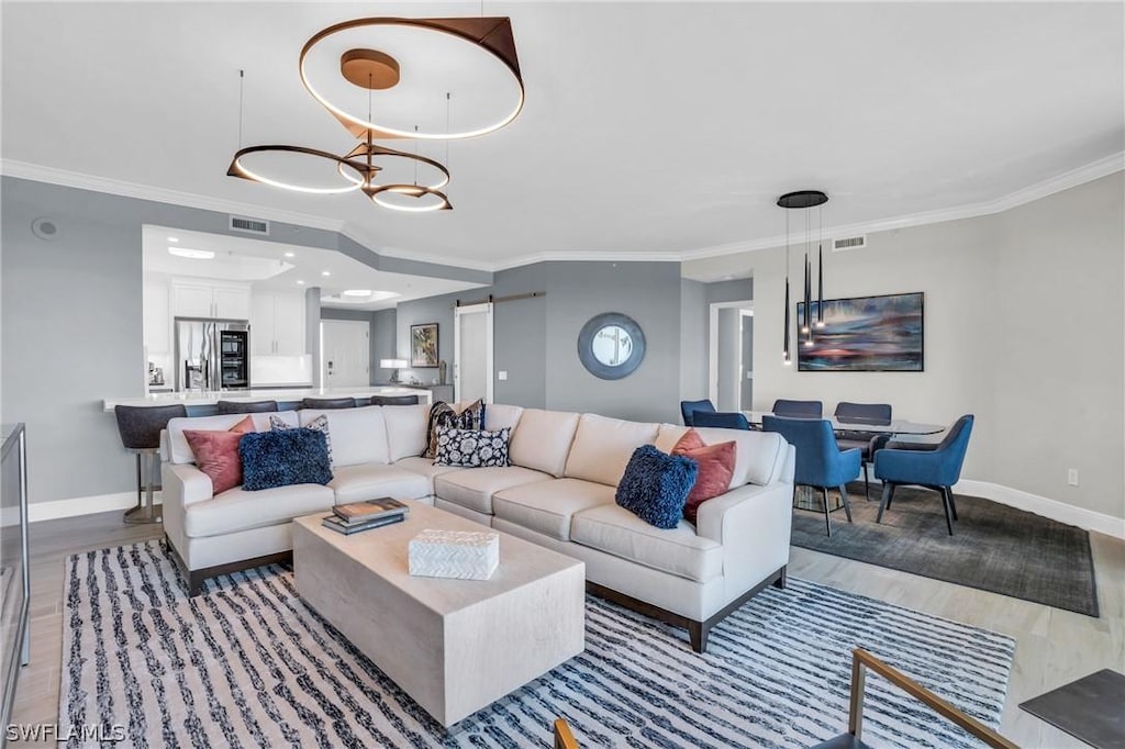 living room featuring crown molding, a chandelier, and hardwood / wood-style flooring