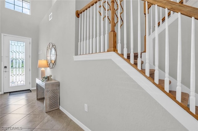 tiled foyer with stairway, visible vents, and baseboards