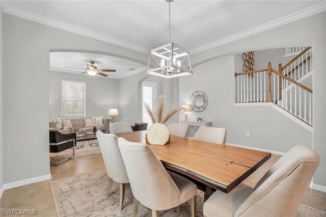 dining space featuring light tile patterned floors, baseboards, arched walkways, stairway, and crown molding