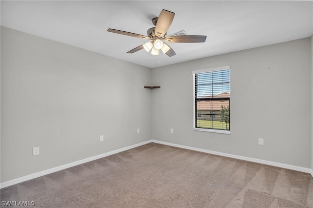 carpeted spare room featuring baseboards and a ceiling fan