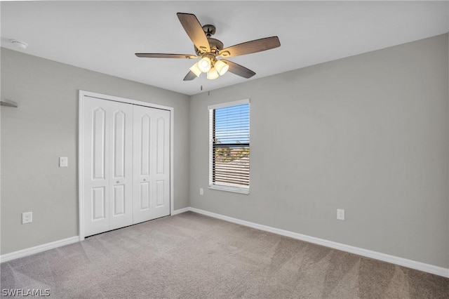 unfurnished bedroom featuring carpet, a closet, ceiling fan, and baseboards