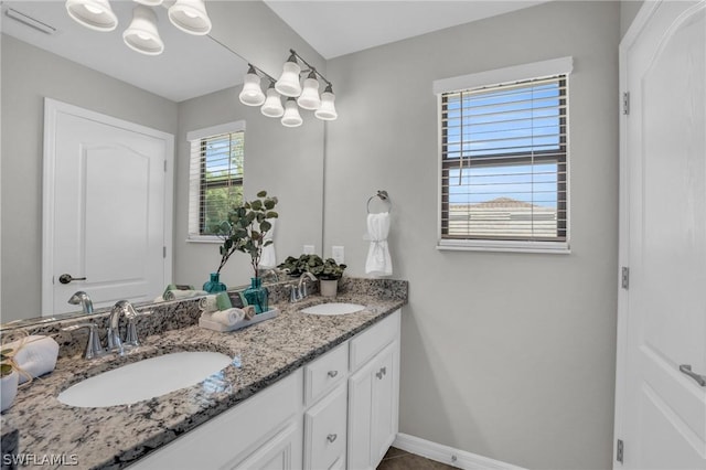 full bath featuring visible vents, a sink, baseboards, and double vanity