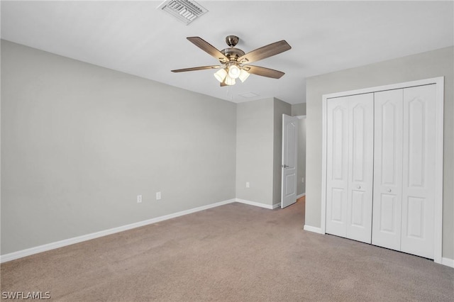 unfurnished bedroom with baseboards, visible vents, ceiling fan, carpet floors, and a closet