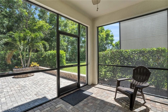 unfurnished sunroom with a ceiling fan