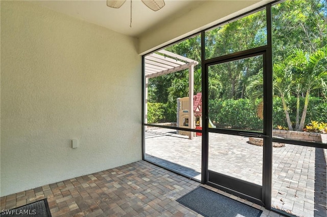 entryway with brick floor, ceiling fan, and a textured wall