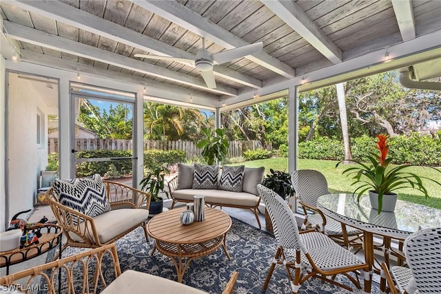 sunroom with ceiling fan, beam ceiling, and plenty of natural light