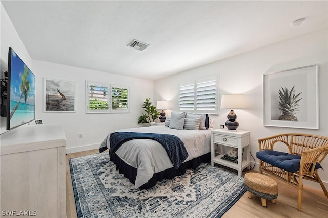 bedroom with wood-type flooring and multiple windows