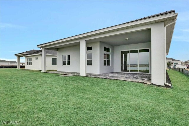 back of house with a yard and a patio area