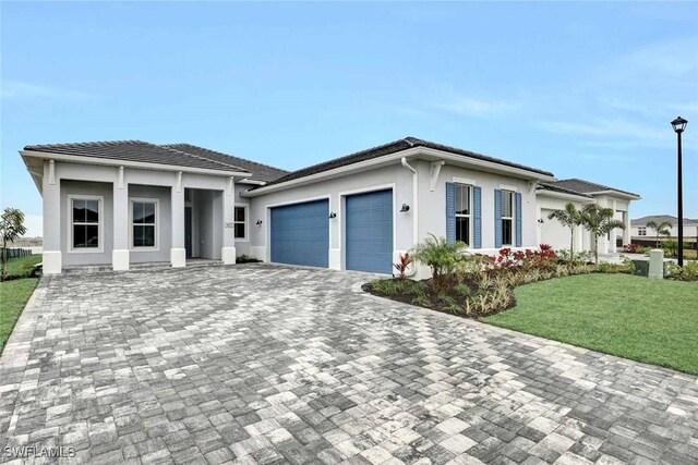 view of front of house featuring a garage and a front lawn