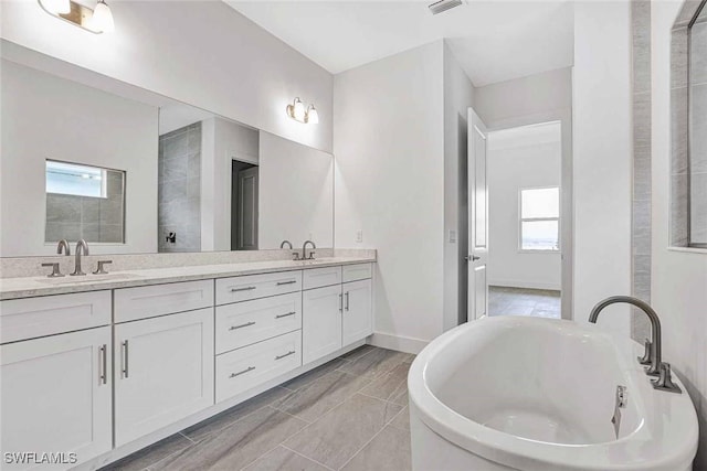 bathroom featuring vanity, a bathing tub, and a healthy amount of sunlight