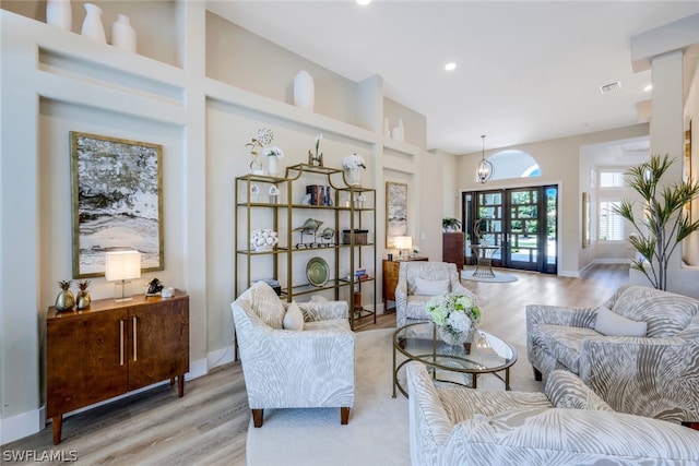 living room featuring french doors and light hardwood / wood-style flooring