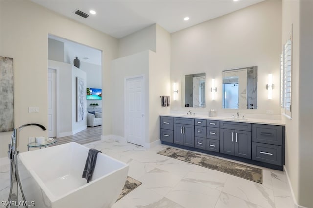 bathroom featuring a high ceiling, vanity, and separate shower and tub