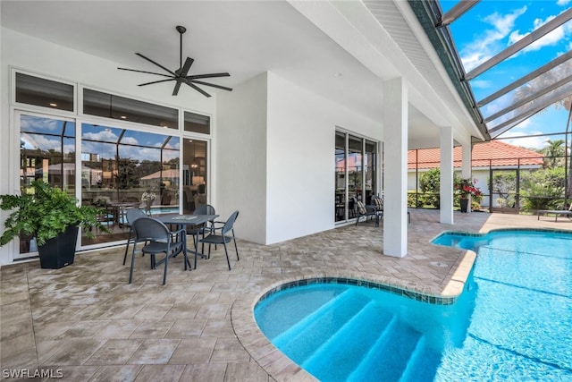 view of swimming pool featuring a patio, glass enclosure, and ceiling fan