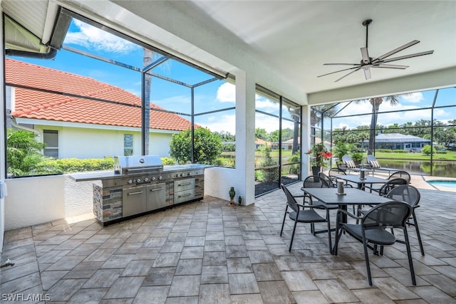 sunroom / solarium with ceiling fan and a water view