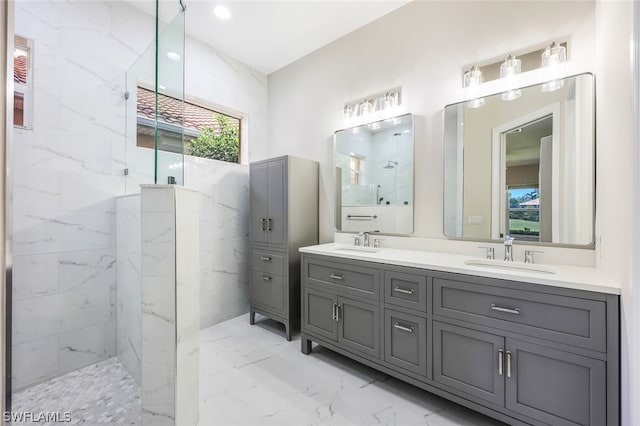 bathroom with a tile shower and vanity