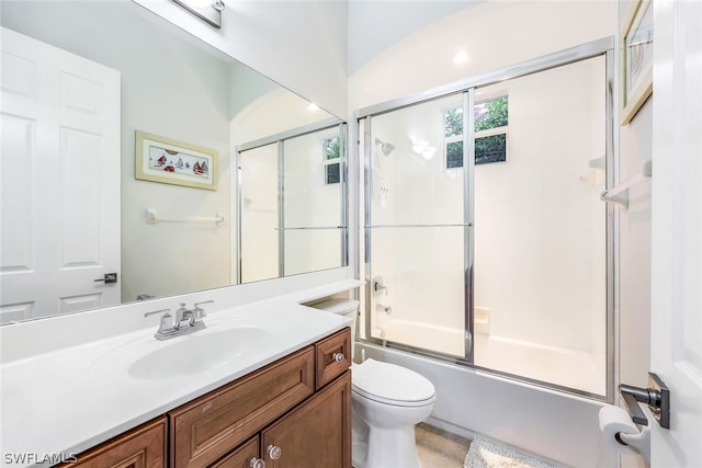 bathroom with toilet, shower / bath combination with glass door, and vanity