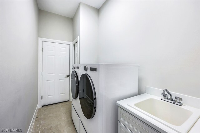 laundry room featuring washing machine and dryer, sink, and light tile patterned floors