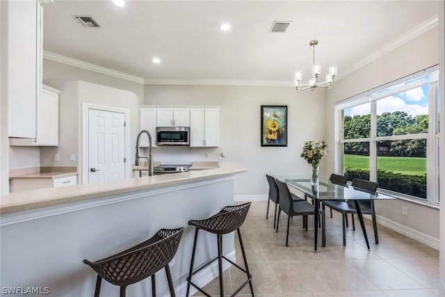 kitchen featuring ornamental molding, appliances with stainless steel finishes, and white cabinets