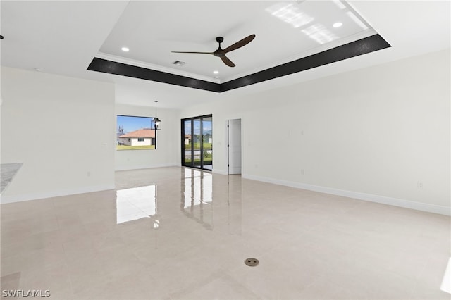 unfurnished room with ceiling fan, a tray ceiling, and crown molding