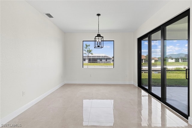 empty room featuring a chandelier and a wealth of natural light