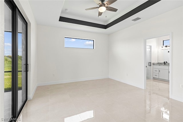 spare room featuring ceiling fan, a raised ceiling, and ornamental molding