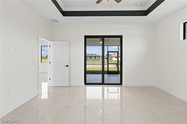 spare room featuring ceiling fan, a tray ceiling, and ornamental molding