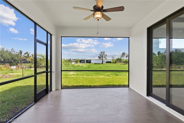 unfurnished sunroom with ceiling fan