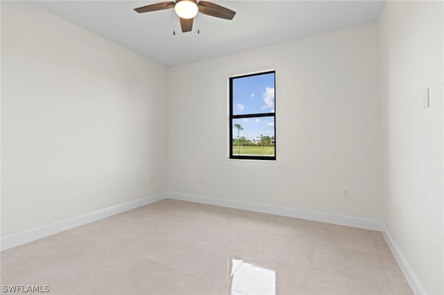 tiled spare room featuring ceiling fan