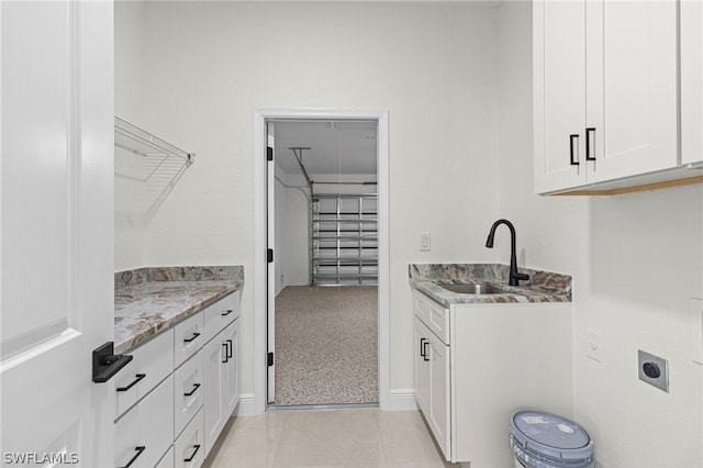 laundry room featuring sink, hookup for an electric dryer, cabinets, and light carpet