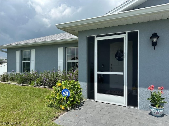 view of exterior entry featuring a yard