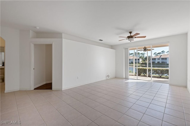 tiled spare room with ceiling fan