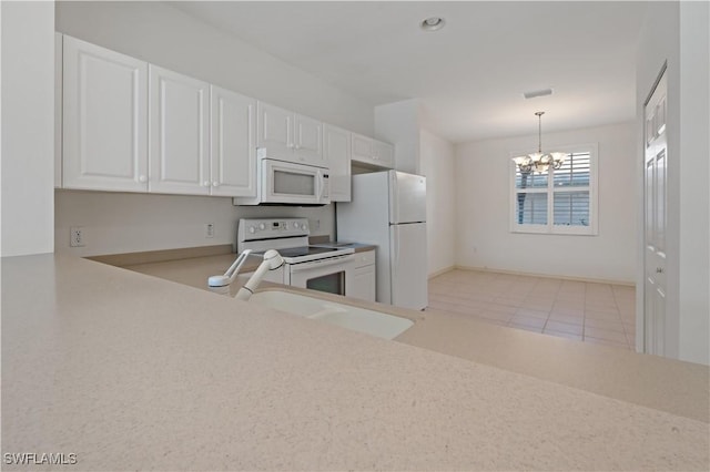 kitchen with white appliances, a chandelier, sink, white cabinets, and hanging light fixtures