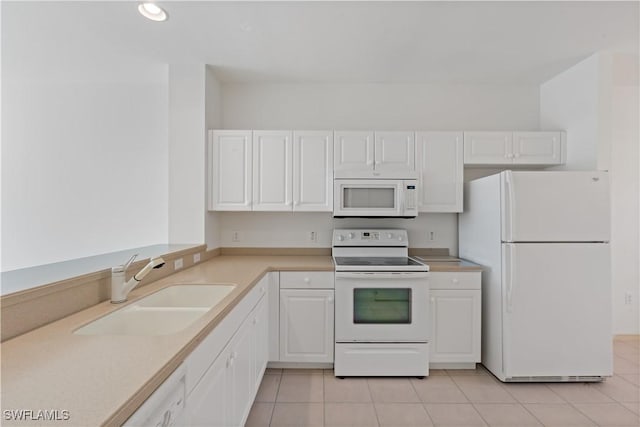 kitchen featuring sink, white appliances, white cabinets, and light tile patterned floors