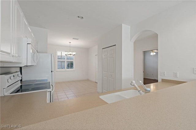 kitchen featuring white appliances, sink, decorative light fixtures, ceiling fan with notable chandelier, and white cabinets