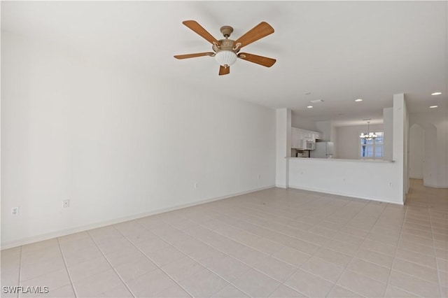 unfurnished living room featuring ceiling fan with notable chandelier